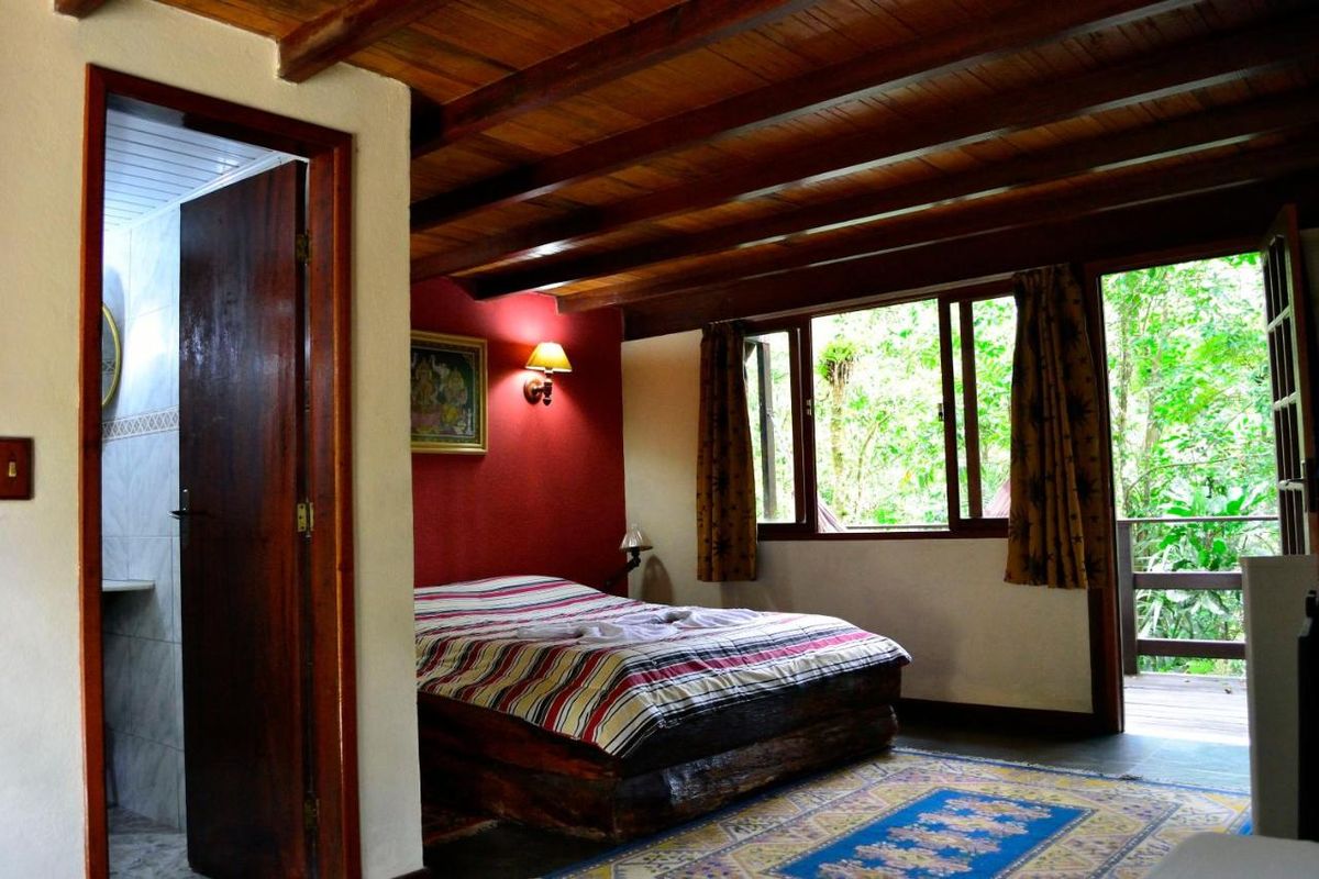 Quarto de parede vermelha e teto de madeira — Chalés Canadenses, Gaura Mandir, Teresópolis
